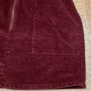 Corduroy burgundy mini w/ long zipper enclosure and flat pockets in front